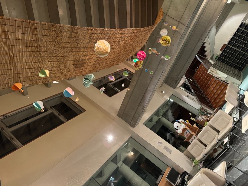 ライトに照らされた傘などの飾りを吊るしている